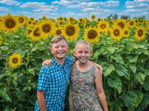 boy and girl in sunflower field